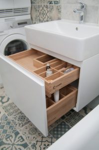 Wooden drawer in the bathroom under the sink with an insert